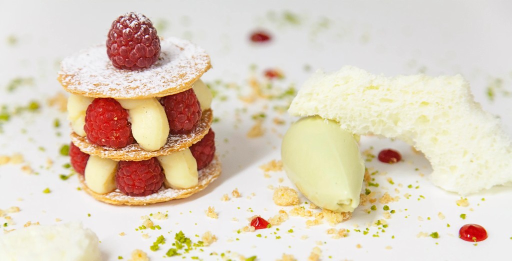 Raspberry mille-feuille with pistachio quenelle on a white plate