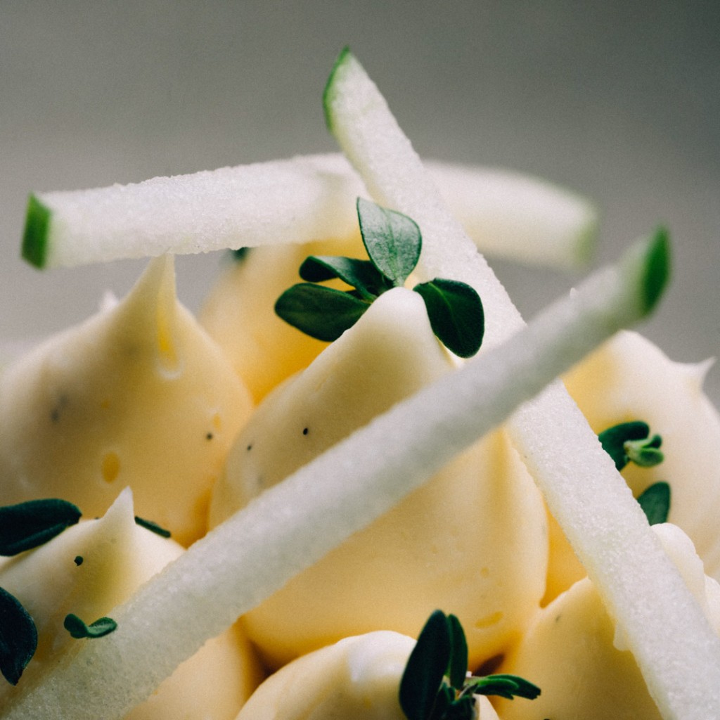 Close-up of pale cream dollops with candied fruit and herbs