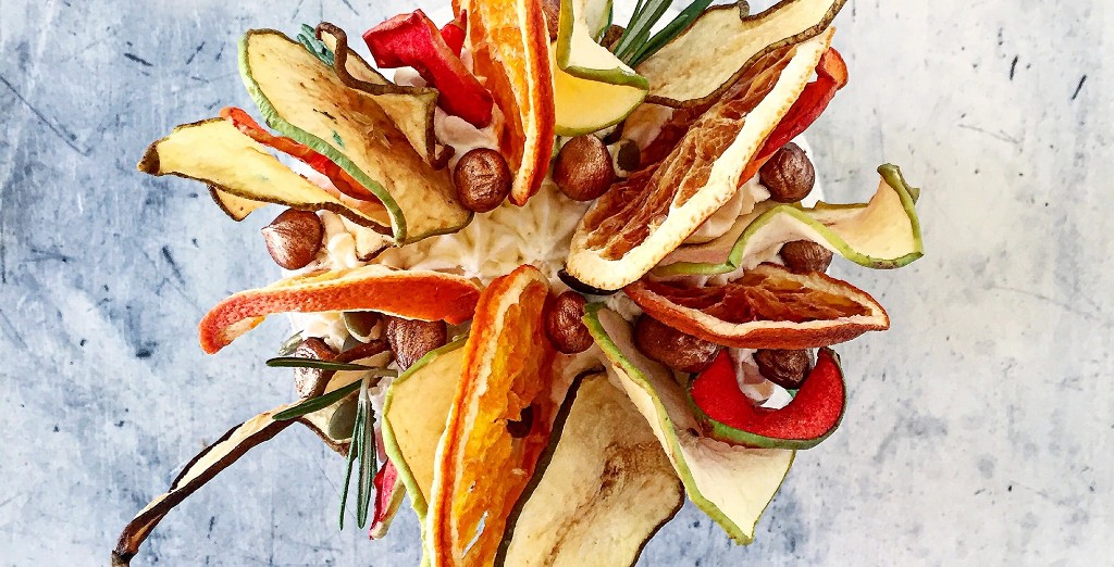 Round tart topped with dried fruit, nuts, and rosemary